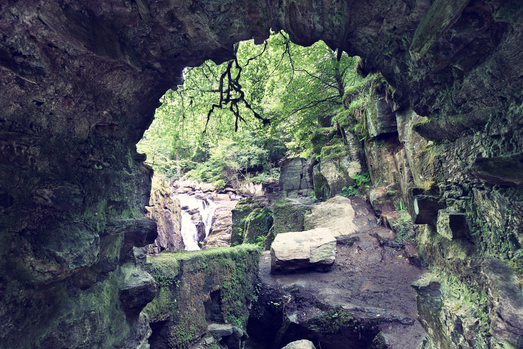 Tunnel under the Hermitage bridge with rocks and moss in Scotland